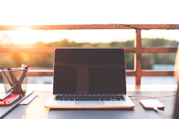 A laptop sitting outdoors at sunset