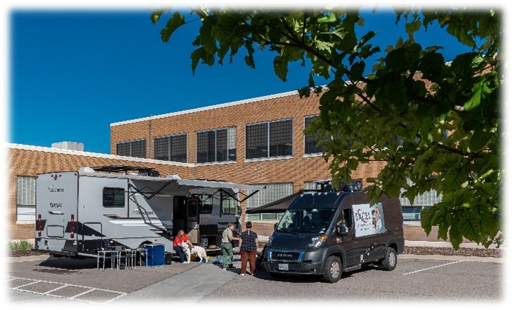 Two Excel RVs in a parking lot